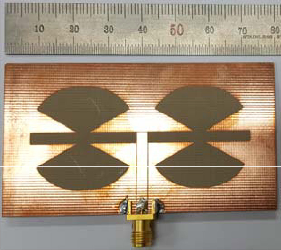 WIDEBAND HARMONIC SUPPRESSION SLOT ANTENNA WITH VERTICAL ROUNDED BOW-TIE SLOTS